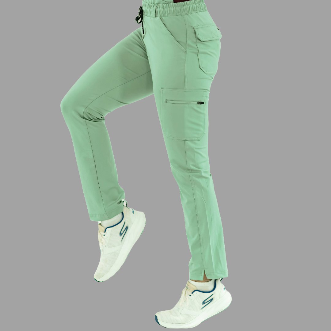 Vista lateral de pantalón médico 930 en verde menta con una pierna levantada.