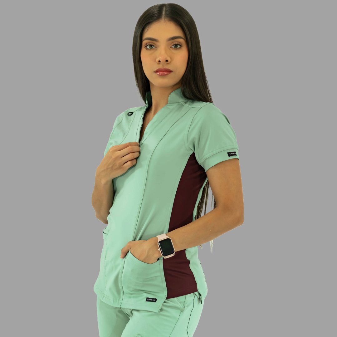 Filipina médica verde menta con detalles vino, vista de tres cuartos ajustando cuello.