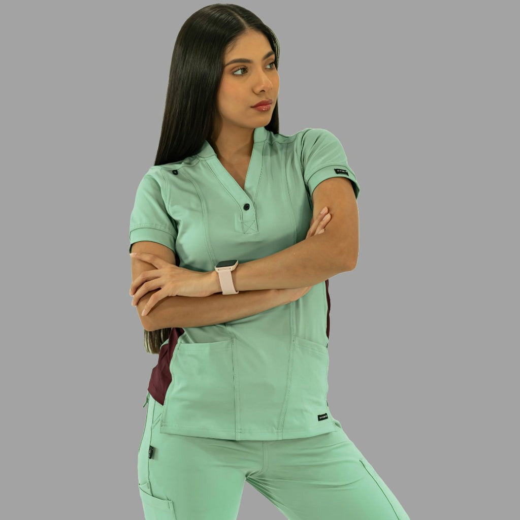 Vista frontal de filipina médica verde menta con brazos cruzados y detalles en vino.