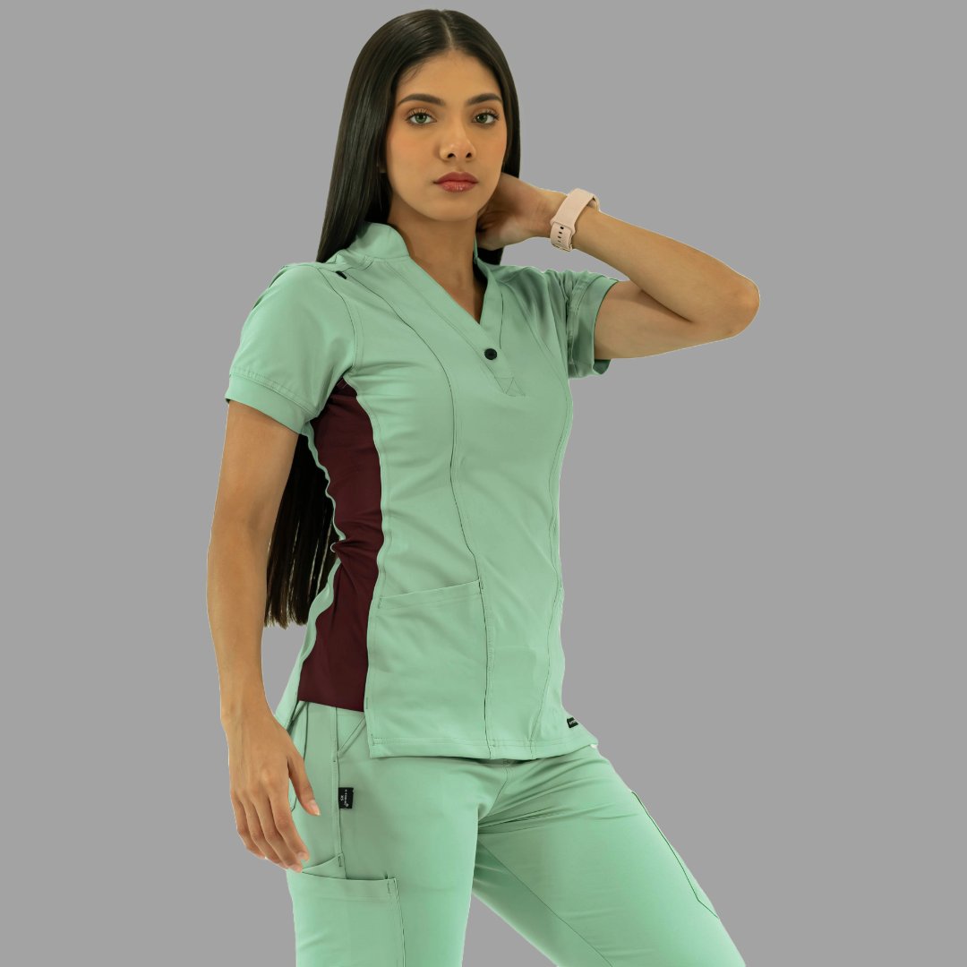 Filipina y pantalón médico verde menta, vista de tres cuartos con mano en el cuello.