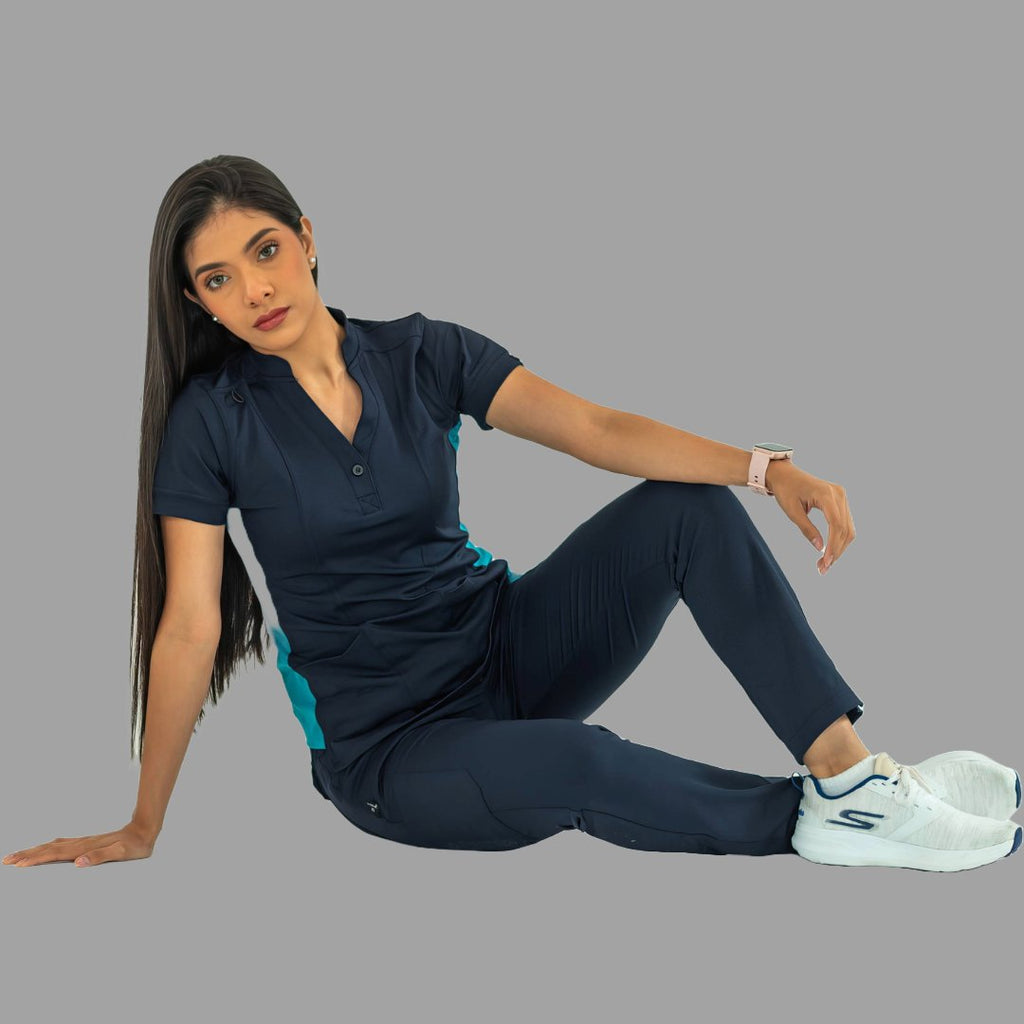 Modelo sentada usando filipina médica 930 azul marino y teal con pantalón médico a juego.