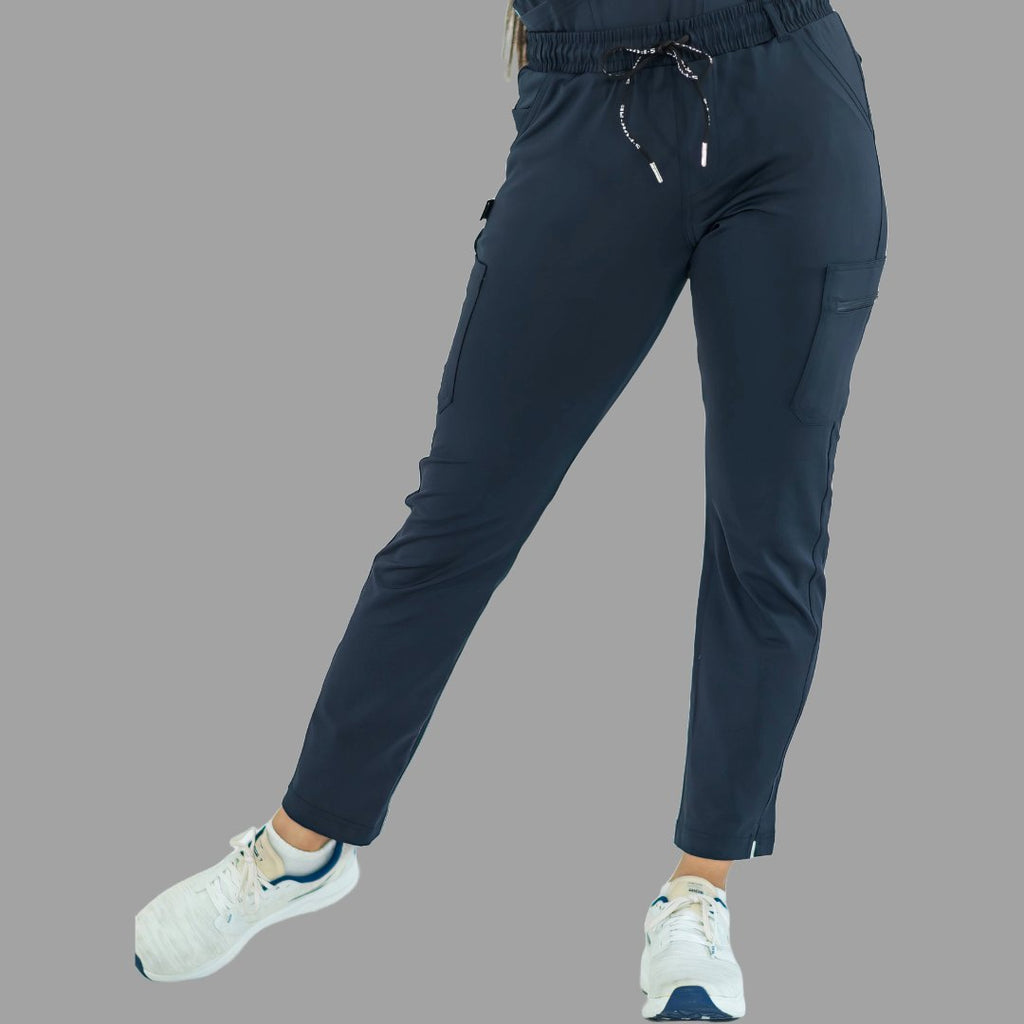 Vista frontal dinámica del pantalón médico azul marino, exhibiendo flexibilidad y corte.