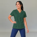 Modelo luciendo la filipina quirúrgica verde botella 502 para mujer, combinada con pantalones azules.